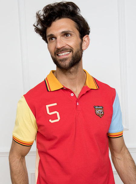 Man wearing multicoloured polo shirt with giant number 5 on the back, made of 100% cotton.